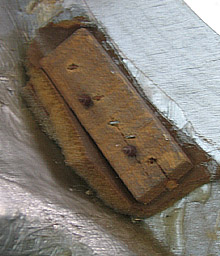 The remnants of the original Shawcraft foam from 1963 screwed in place under a wooden block